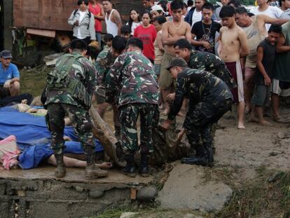 Soldados filipinos juntan cadáveres de fallecidos en las inundaciones al sur del país.