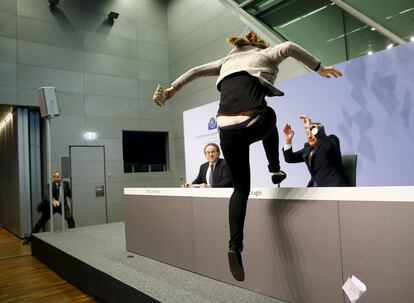 Una activista burla las medidas de seguridad del BCE e interrumpe a gritos la comparecencia de Draghi en Fráncfort, Alemania.