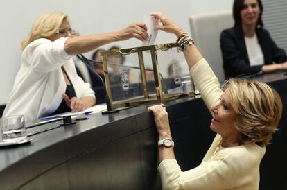 Esperanza Aguirre deposita su voto ayudada por Manuela Carmena.