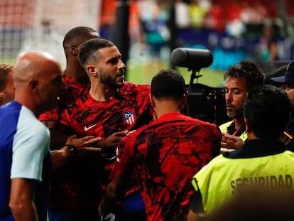 Mario Hermoso es sujetado por miembros del cuerpo técnico del Atlético tras su enfrentamiento con los ultras rojiblancos en el Metropolitano al término del partido con el Villarreal disputado el pasado domingo.