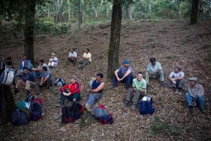 Los miembros de la cuadrilla que trabajan en la saca del corcho en la finca Los Gavilanes del parque natural Los Alcornocales esperan reunidos a que sea la hora de comer.
