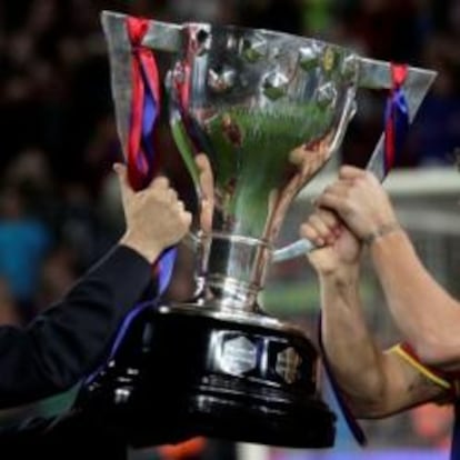 El presidente de la Real Federación Española de Fútbol, Angel María Villar, entrega la copa de campeón de liga al capitán del F.C. Barcelona, Carles Puyol.