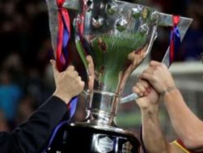 El presidente de la Real Federación Española de Fútbol, Angel María Villar, entrega la copa de campeón de liga al capitán del F.C. Barcelona, Carles Puyol.