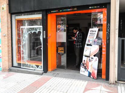 Un cliente consulta su móvil en la tienda de Orange asaltada ayer en la calle de Alcalá.