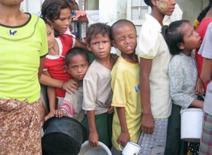 Niños huérfanos a causa del ciclón Nargis esperan a recibir comida en un colegio de Dalah