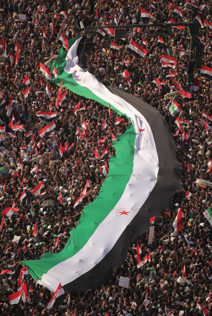 Los manifestantes de la plaza Tahrir extienden una bandera de Siria, ayer en El Cairo.