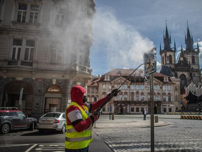 Un trabajador limpia una señal de tráfico en Praga (República Checa) el 1 de mayo