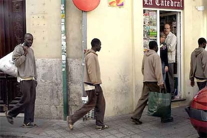 Varios inmigrantes <i>sin papeles</i> procedentes de Canarias, ayer, en una calle de Valladolid, donde han sido acogidos por Cruz Roja.