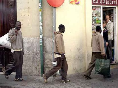 Varios inmigrantes <i>sin papeles</i> procedentes de Canarias, ayer, en una calle de Valladolid, donde han sido acogidos por Cruz Roja.