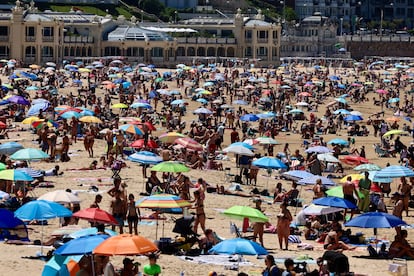 Centenares de personas en la playa de La Concha en San Sebastián, este domingo.