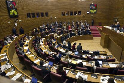 Los diputados del PP, de pie, aplauden la reforma del Estatut aprobada en el pleno de las Cortes Valencianas de ayer.