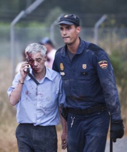 Francisco Jos&eacute; Garz&oacute;n Amo is led away from the crash site in Angrois, outside Santiago de Compostela. 