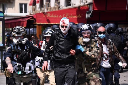 Um manifestante ferido durante os tumultos nas manifestações de 1º de maio em Paris é atendido por serviços de emergência.