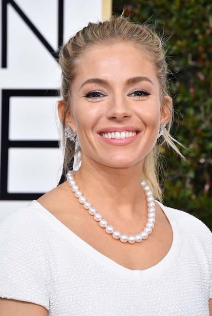 Sienna Miller combió su vestido de Michael Kors con un clásico collar de perlas.