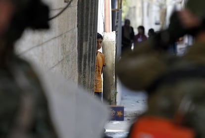 Un niño palestino mira a las tropas israelíes que pasan por los callejones del campo de refugiados de al-Arrub, en el sur ocupado de Cisjordania.