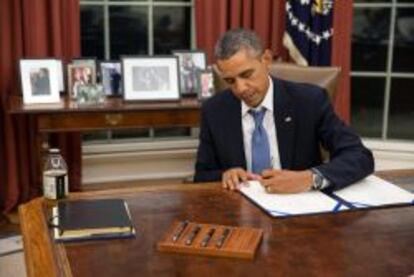 El presidente Barack Obama mientras firma el documento H.R. 3210, para el pago de los miembros de las Fuerzas Armadas durante el tiempo que dure el bloqueo presupuestario