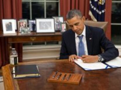 El presidente Barack Obama mientras firma el documento H.R. 3210, para el pago de los miembros de las Fuerzas Armadas durante el tiempo que dure el bloqueo presupuestario