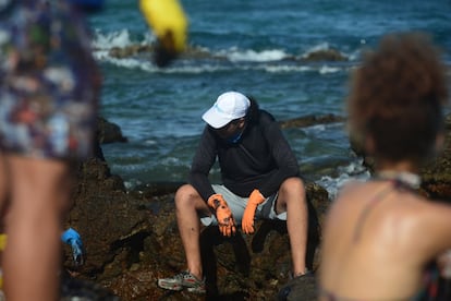 Um homem que ajuda na limpeza faz uma pausa para descansar.