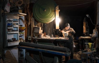 Giovanni, viejo pescador de 94 años, construye barquitos de madera en su taller.