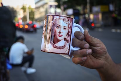 Comerciantes venden productos con retratos de Silvia Pinal impresos en ellos frente al Palacio de Bellas Artes, durante el homenaje póstumo de la actriz. 