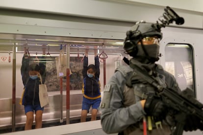 Dos niñas juegan dentro de la réplica de un vagón de tren durante una jornada de puertas abiertas para conmemorar el Día de la Educación en Seguridad Nacional, en la Escuela de Policía de Hong Kong (China), el 15 de abril de 2021.