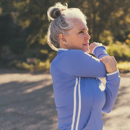 Mature woman stretching before exercise on sunny day