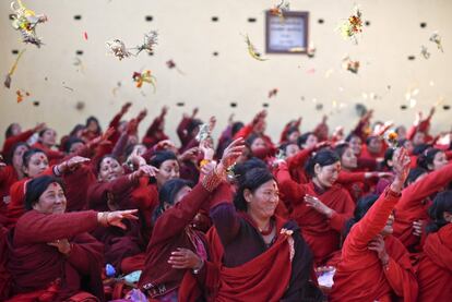 Varias mujeres lanzan flores durante el popular festival hindú de Swasthani celebrado en Katmandú (Nepal).