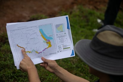 Un miembro de la fundación del río, señala en un mapa el sitio donde los colonos armados han llegado a invadir la reserva.