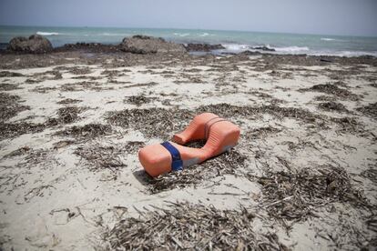 Un chaleco salvavidas permanece tirado en una playa donde han aparecido los cuerpos sin vida de inmigrantes al oeste de Trípoli, en Libia.
