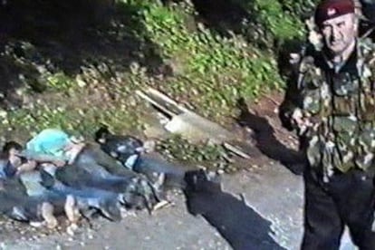 Un policía serbio aparece en el vídeo junto a varios prisioneros con las manos atadas a la espalda.