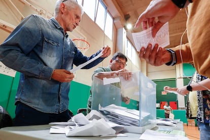  Los miembros de una mesa electoral proceden a la apertura de las urnas para el recuento de votos, tras el cierre de los colegios electorales este domingo.