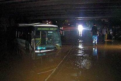 El autocar de la empresa Sagalés, el domingo, en medio del agua bajo la autopista AP-7.