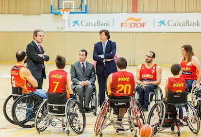 El presidente de CaixaBank, Jordi Gual (izquierda), el presidente de la FEDDF, José Alberto Álvarez (centro), y el del Consejo Superior de Deportes, José Ramón Lete (derecha), charlan con jugadores de las selecciones femenina y masculina de baloncesto en silla.