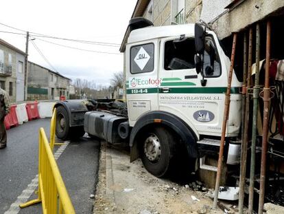 Un vecino de Loiro junto al cami&oacute;n empotrado en una vivienda 