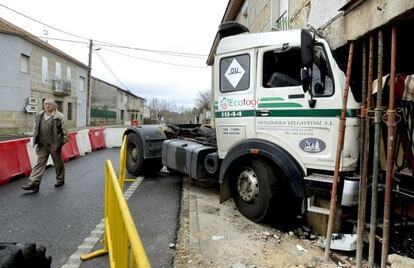 Un vecino de Loiro junto al cami&oacute;n empotrado en una vivienda 