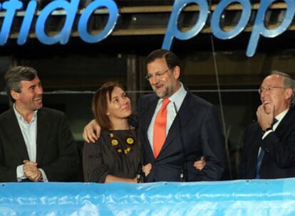 Rajoy, con su esposa, Elvira Fernández; Ángel Acebes, y Manuel Pizarro, en el balcón de la sede del PP desde el que saludaron a sus simpatizantes.