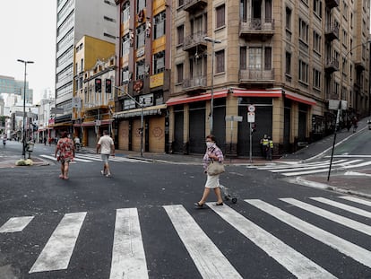 Personas pasan frente a tiendas cerradas en São Paulo.