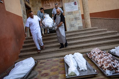 Personal de la morgue del hospital de Jan Yunis sacan los cadáveres de varias personas para ser entregados a sus familias, este sábado. 