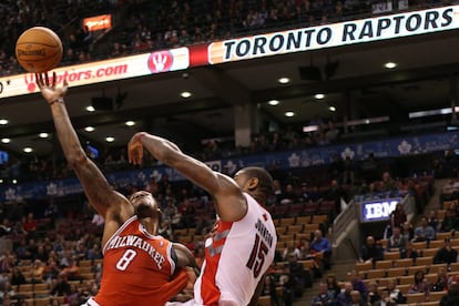 Amir Johnson, de los Raptors, frena la incursión de Larry Sanders, de los Bucks.