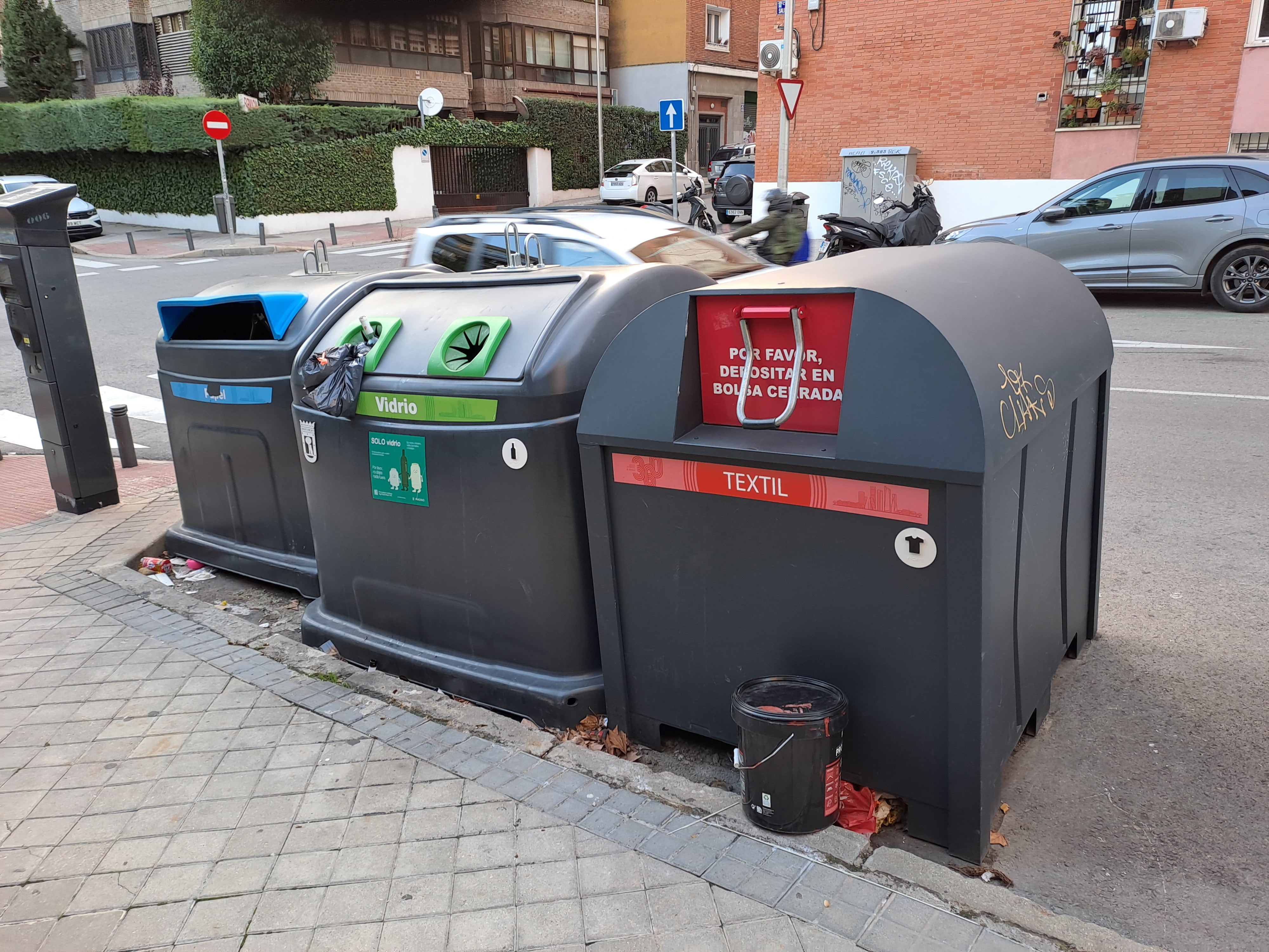 Contenedor rojo para recoger ropa usada y residuos textiles, en una calle de Madrid.