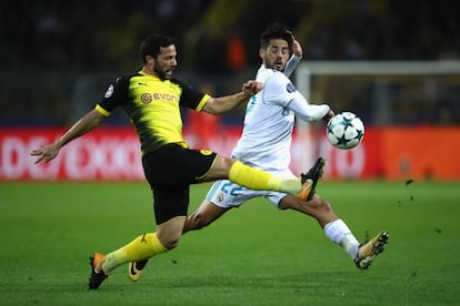 El jugador del Borussia, Gonzalo Castro, golpea el balón ante la presión del jugador del Real Madrid, Isco.