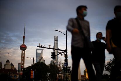 People wearing face masks walk through Shanghai on September 21.