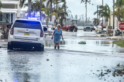 Una mujer camina por una calle inundada tras el paso del huracán en Bradenton, Florida.