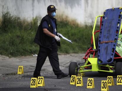 Un policía examina la escena de un tiroteo en una pista de karts en el que murieron dos hombres el 7 de octubre.