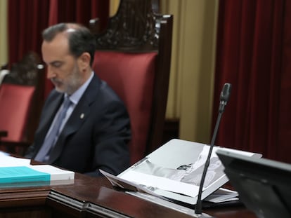 En primer plano, la foto de tres mujeres fusiladas por falangistas en Mallorca rota en el pleno del Parlamento balear por su presidente, Gabriel Le Senne (en el centro de la imagen), de Vox.