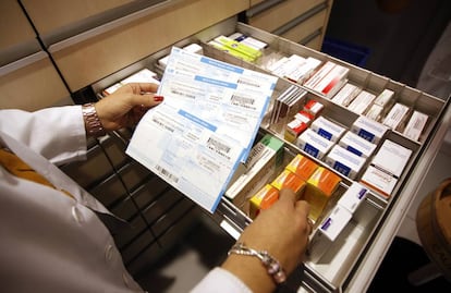 Una farmacéutica coteja recetas en papel en Boadilla.