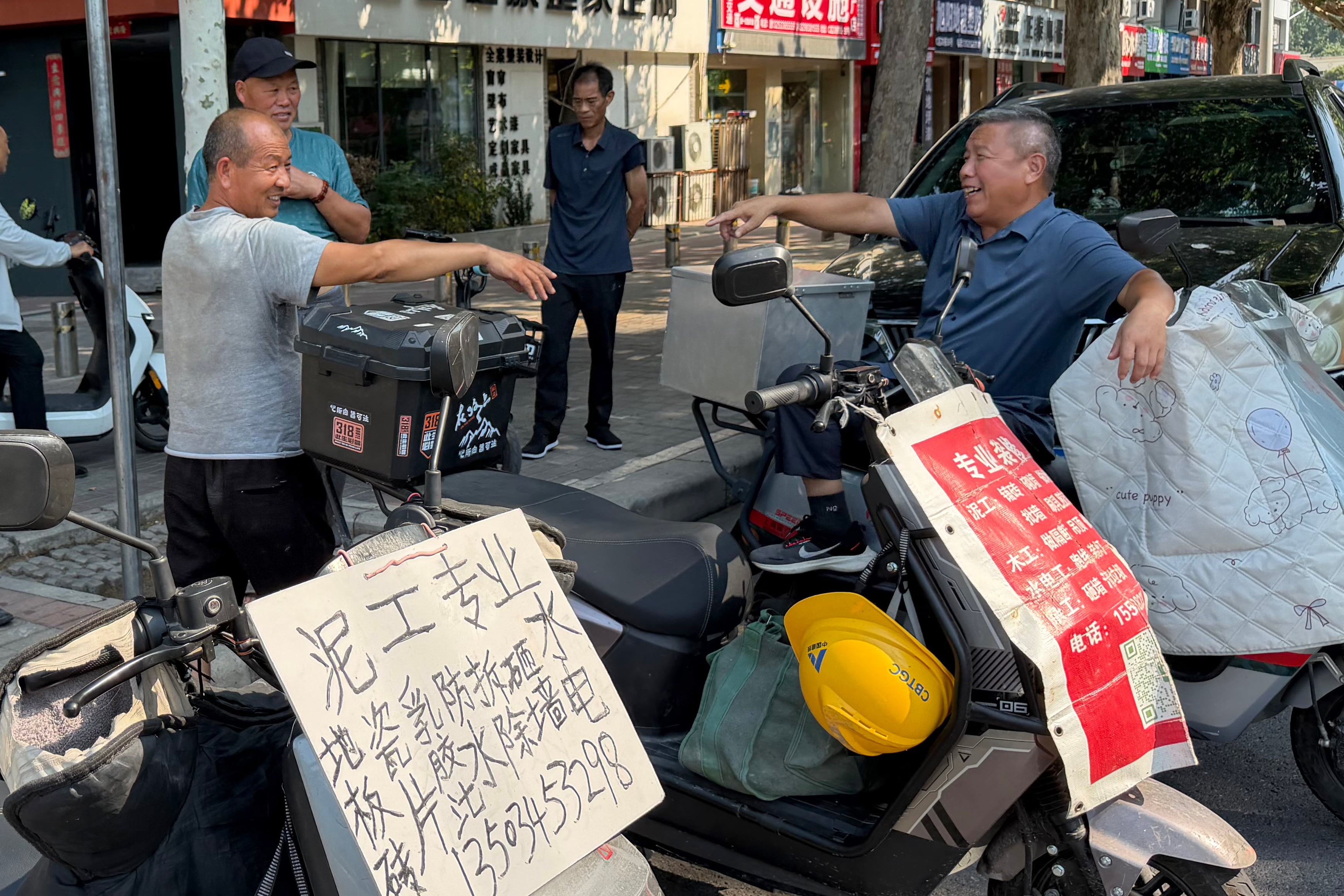 Un grupo de trabajadores de la construcción espera la llegada de algún cliente en las inmediaciones de Dongjiancai, en Zhengzhou, China, el 8 de julio de 2026.
