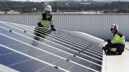 Dos operarios colocan un panel solar de EDP. 