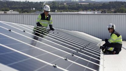 Dos operarios colocan un panel solar de EDP. 