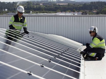 Dos operarios colocan un panel solar de EDP. 
